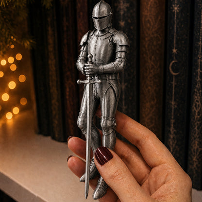 The Sentinel Knight held in a hand in front of a bookshelf
